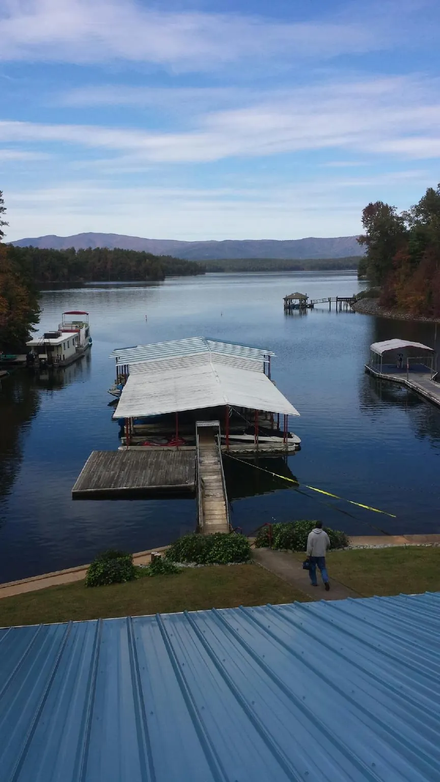 View across a lake from a newly installed blue metal roof in Loomis